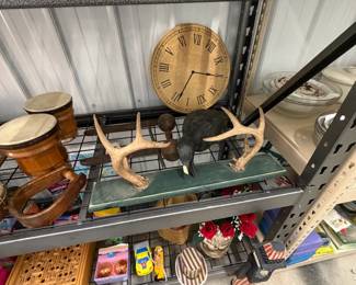 Wall clock, antlers, and bongo drum.