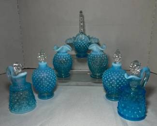 Fenton Blue Opalescent Hobnail Basket, Pitchers and Perfume Bottles - Fenton blue opalescent hobnail glass including a basket with a clear handle, two handled pitchers, two stoppered perfume bottles, and two ruffled vases. A good lot for hobnail glass collectors.