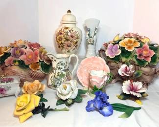 Porcelain Flower Centerpieces, Porcelain Flowers and Floral Ginger Jar, Pitcher and Trinket Box - Two large porcelain flower centerpieces, a yellow rose, white magnolia, blue iris, and pink hibiscus, a flower shaped cup and plate, a floral ginger jar with gold trim, a floral pitcher, a white vase with applied flowers, and a footed trinket box with pink roses. A bright lot for floral decor fans.