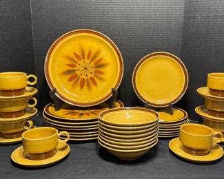 Retro Mustard and Brown Stoneware Dinnerware Set with Starburst Design - A stoneware dinnerware set with a starburst pattern, including dinner plates, salad plates, bowls, cups, and saucers. A good set for retro kitchen fans.