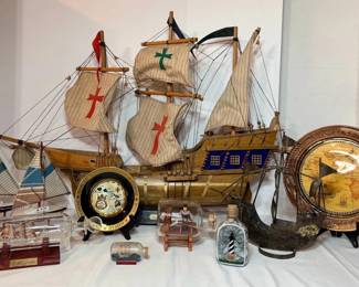 Wooden Sailing Ship Model, Sailboat Models, Ships in Bottles and Hawaii Souvenir Plates - A large wooden sailing ship model with cross sails, two wooden sailboat models with striped sails, a ship in a large glass bottle on a wood stand, small ships in bottles, a lighthouse bottle, and two Hawaii plates on stands. A good lot for nautical collectors.