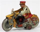 Lot#239, U.S MAR TOY MECHANICAL YELLOW-MOTORCYCLE TIN COP WITH RED-PANTS WORKING ORDER KEY WIND, 1, L 8"Three Wheel Yellow Motor Cycle.   -   Tin, Rubber, Wood Wheels.    Size: Height 5 3/4" High x 8" Long x 3" Depth with keywind.    -      -