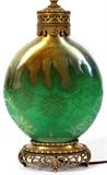 Lot#1004, STEUBEN ACID CUT-BACK POMONA GREEN & GOLD AURENE GLASS LAMP, H 9" (BASE), H 20" OVERALL,Flask form Pomona green glass with an acid-etched floral motif, H.9", cased with gold aurene at the shoulders, measures H.20" overall.  Early 20th century.  Reference: "The Glass of Frederick Carder", Paul V. Gardner, copyright 1971, Crown Publishers, New York, catalog line number 8492 (p.302).
