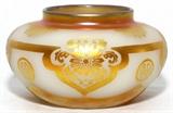 Lot#1007, STEUBEN ACID CUT-BACK ALABASTER & GOLD AURENE GLASS VASE, H 4 1/4", DIA 7"A round alabaster glass vase with acid cut-back Asian medallion motif, heightened with gold aurene.  No apparent markings.  Early 20th century.