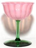 Lot#1038, STEUBEN ORIENTAL POPPY GLASS CHAMPAGNE, H 4 3/4", DIA 3 7/8"A champagne, or wine glass, having a pink ribbed bowl raised on a green stem and base.  Not signed.  Early 20th century.
