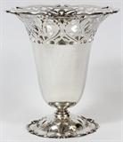 Lot#1165, FRANK SMITH SILVER CO. STERLING VASE, EARLY 20TH C., H 9 3/4"Pierced fleur de lis and scroll pattern, stamped at the underside, number 2932, and retailed by Cowell & Hubbard Co. (see additional photo).  Diameter 9 1/4" at the widest point.  Weighs approximately 26.2 troy oz.