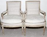 Lot#1314, LOUIS XVI STYLE ANTIQUED WHITE ARMCHAIRS, PAIR: Each having an upholstered back and loose seat cushion flanked by padded open arms, antiqued white hand carved frames. Distressed frames, antique white over walnut. Good condition jw