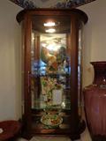 Fitz & Floyd pieces in curved glass display cabinet