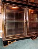 Oriental black lacquer china/curio cabinet from Plunketts.  Decorated with oriental scenes, flowers, foliage, etc.  Six beveled glass door, glass shelves, top and bottom section individually lighted.  Separates into two pieces.