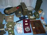 military memorabilia including items like gas masks in canisters, Army Air Force survival vest iwth all the pockets filled, medals, and more...