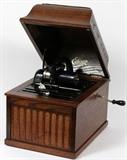 Lot#166, THOMAS EDISON PHONOGRAPH, 18 ROLLS, OAK H 12" W 16" D 11 1/2"18 ROLLS INCLUDED. Cylinder style.