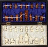 Lot#1143, CHINESE CARVED IVORY CHESS SET, 32 PIECES, H 4", ENCASED.Set includes a wooden case with chess board top, holding 32 carved ivory figural pieces, 16 of which are tinted. Pieces measuring from 2" to 4" in height.