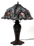 Lot#2181, TIFFANY STYLE LEADED GLASS, TWO-LIGHT TABLE LAMP, H 25", DIA 18"The modern lamp has an illuminating base accented by multi-colored leaded glass.
