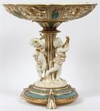 Lot#2258, MINTON PORCELAIN PEDESTAL BASE CENTERPIECE COMPOTE, H 14", DIA 14"H 14 1/2"; Dia 14 1/4"; molded cupid musicians; pierced bowl; turquoise and white with fired gold; unmarked.