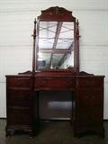 Drexel Mahogany Vanity from The Newport Collection. Features carved boarders and columns, original mirror with turned risers, and seven pull out drawers with original hardware. Measures 49"w. x 72"h. (with mirror) x 19"d.