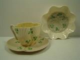 Belleek Teacup, Saucer, and Ruffled Dish all with Clover Designs. All marked with Belleek black ink stamp. Cup measures 2.5"h. and saucer and dish measure 5"w. All are in Good Condition. 