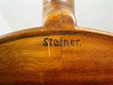 Antique Stainer Violin. At one time this was a very high quality violin and is still considered worth restoring. Please see photos for condition. Measures 24"h. x 8.5"w. 