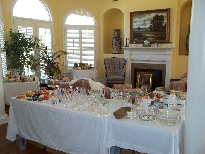 Chock full of glass ware and fine items. A very beautiful centerpiece is on a square glass coffetable