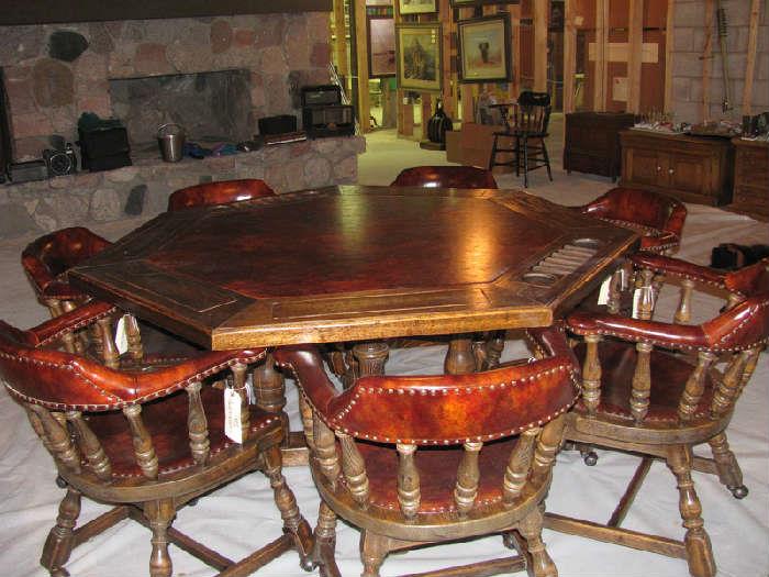 Octagon game table with 7 nail head chairs covered in a burgundy leather.