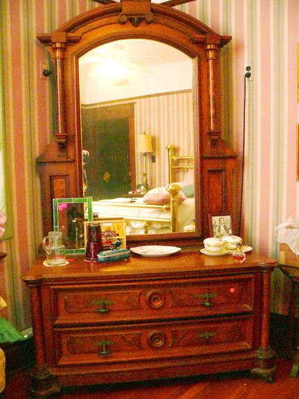 Walnut, princess dresser with burl accent, beveled mirror and hidden drawer on bottom.