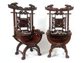 Lot 1041:  PAIR PROFUSELY CARVED ORIENTAL DRAGON CHAIRS: Carved all over with full figural dragons at top crest and arms. Back with foliate and floral motifs, shaped fluted seat. Front with masqueron under seat, ending in paw feet. 60'' h. x 34 1/2'' x 25 3/4''.
CONDITION: Dragon on arm missing an eye. Other wear consistent with age and use.