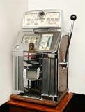 Lot 1221:  JENNINGS GOVERNOR 25 CENT TIC TAC TOE SLOT MACHINE & STAND: 3 reels, chrome front with figural Indian bust at center. Oak sides, black metal back. Circa 1940's, top and instruction panel with Tic-Tac-Toe game inserts. Measures 28'' x 19 1/2'' x 17''. Sold with wood stand, 34'' x 17 3/4'' x 17''.
CONDITION: Machine works sporadically, will need some adjustments, uneven chrome finish. Base with uneven finish. Keys in office.