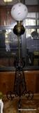 Antique standing lamp was once oil converted to electric, wrought iron base