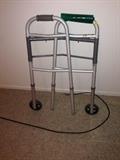 Lot #50 
Adjustable walker with wheels has some handle wear.