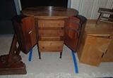 Sewing Cabinet 	 

Labeled The New Martha Washington Table by Miller Cabinet Company, patented 1917. Three drawers, two side compartments that swing out. Two dowels for thread spools. Removable tray container. Small stains to surface top. 27X14X27. 	

	
http://auctionnearyou.maxsold.com/view-auctions/catalog/id/378/lot/41027/?url=%2Fview-auctions%2Fcatalog%2Fid%2F378%2F%3Fpage%3D1%26items%3D100
