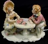 134 - Porcelain little boy and girl at tea table.