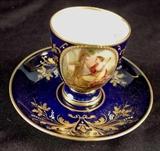174 - Austrian demitasse C & S hand painted and signed with Victorian lady on front, gold and cobalt.