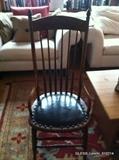 Antique spindle back chair (tall back). Cane seat covered in black leather (one of two.)