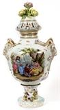 Lot#1002, CARL THIEME, DRESDEN PORCELAIN COVERED URN, C. 1900, H 27", W 15"Painted at the front and back with figures in a landscape, flanked by molded ram's mask handles, floral adornments at the base, and surmounted by a pierced cover centered by three roses, blue mark at the underside for Carl Thieme, Saxonian Porcelain Factory, Potschappel-Dresden, Germany, circa 1888-1901 (see additional photo).