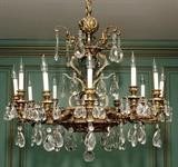 Lot#1028, GILT METAL & CRYSTAL TWELVE-LIGHT CHANDELIER, H 30", DIA 30"Ornate gilt metal frame hung with crystal prisms.