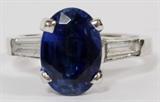 Lot#1130, PLATINUM, 3.47CT NATURAL KYANITE & DIAMOND RING, 4.9GR,Featuring an oval 3.47 carat natural Kyanite center stone, flanked by two baguette diamonds at the band, measuring 0.50 carats in total weight. The total weight of the ring is approximately 4.9 grams. Size 6.5.
