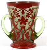 Lot#1230, ACID CUT-BACK GLASS LOVING CUP, C. 1900, H 7 1/4"Light green glass with acid cut-back flowering vine motif decorated in brick red with gilt accents.  No apparent markings.