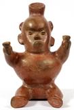 Lot#1316, PRE-COLUMBIAN STYLE POTTERY FIGURAL VESSEL, H 9 3/4'', W 7''Seated figure with broad chest, holding objects with raised arms. Decorated in red.