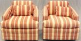 Lot#1541, TUB STYLE UPHOLSTERED SWIVEL CHAIRS, PAIR,Two tub chairs upholstered in striped red/blue/white on upholstered round swivel base, each with an accent pillow.  Measures H.29" x 29" x 33".