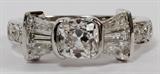 Lot#2054, GIA 18KT WHITE GOLD 1.02CT DIAMOND RING, 7.4GR,Featuring a 1.02 carat cushion brilliant cut center diamond, measuring 5.86 x 5.66 x 3.94mm, with a F-color, VS-1 clarity grading, flanked by 1.00 carats of baguette diamonds, with round diamonds along the band, measuring .70 carats in total weight, side diamonds have a G-color, VS-2 clarity grading. The total weight of the ring is approximately 7.4 grams. Size 6.5.