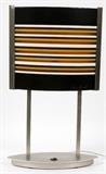 Lot#2154, FENISON & BARONELLI, MODERN DESK LAMP, H 20"With a glass shade, decorated with linear design in brown, cream, and mustard on black, signed lower right.