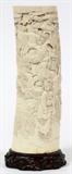 Lot#2289, JAPANESE CARVED IVORY TUSK, H 8 1/2" W 2 1/2"Item to be sold in the USA only. Decorated with a landscape scene of figures and birds carved in relief. Mounted to a wood stand. Signed at lower left side. Measuring H. 8 1/2" x 2 1/2".