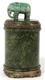 Lot#2306, CHINESE FARMER STYLE, JADE & STERLING CYLINDER JAR, H 6"Having a hinged lid top with carved elephant finial, mounted in sterling silver. Measures H. 6" x 3".