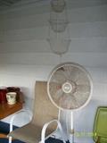 standing fan and 1 of 4 patio chairs