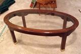 Oval glass top coffee table with mahogany finish