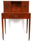 Lot#1252, ROBERT IRWIN SATINWOOD WRITING DESK, H 39", W 27", D 18"Having hand painted figural medallions on each cabinet door flanking a center drawer and cubicle above a desk with slide open top; hand painted designs depicting flowers, quill and inkwell on the façade; also one drawer on the left side with brass hanging ring pull; Square tapered legs with metal castors. Circa 1935.