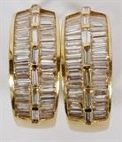 Lot#2218, 14KT GOLD BAGUETTE DIAMOND SEMI HOOP EARRINGS, 16GR, PAIR, L 1"14kt yellow gold semi hoop earrings, featuring channel set baguette diamonds at the front, measuring L. 1", with an approximate total weight of 16 grams.