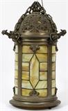 Lot#195, LEADED GLASS LANTERN STYLE CHANDELIER, C. EARLY 1900'S H 17", DIA 8"Hanging lamp/chandelier, pierced design rounded top with acorn finial, cylindrical body, caramel glass throughout and on underside. Suspended by chains. Gargoyles on edge of top.