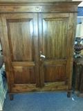 beautiful armoire with a small palm tree motif emblem and knob