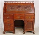102 - Mahogany slant front desk with carved front and gallery on top, 96in. T, 42in. W, 19in. D.