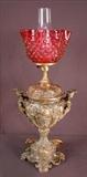 148 - Banquet lamp with figural and cranberry shade, 27in. T.